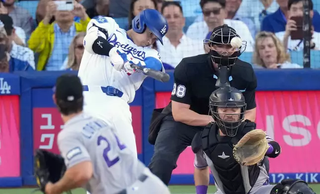 Los Angeles Dodgers' Shohei Ohtani, second from left, hits a solo home run as Colorado Rockies starting pitcher Michael Lorenzen, left, and Braxton Fulford watch during the first inning of a baseball game Tuesday, July 7, 2026, in Los Angeles. (AP Photo/Mark J. Terrill)