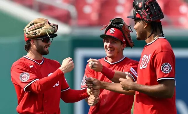 Washington Nationals left fielder Dylan Crews, left, center fielder Jacob Young, center, and right fielder James Wood, right, celebrate after their team's victory over the Arizona Diamondbacks in a baseball game, Sunday, July 26, 2026, in Washington. (AP Photo/John McDonnell)