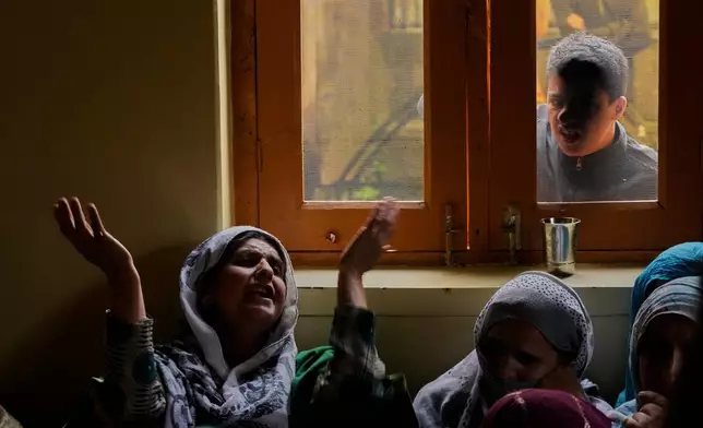 A family member of slain police officer Ashiq Hussain wails inside his home in Lalpora, northwest of Srinagar, Indian-controlled Kashmir, after he was killed in a suspected militant attack in south Kashmir, Wednesday, July 22, 2026. (AP Photo/Mukhtar Khan)