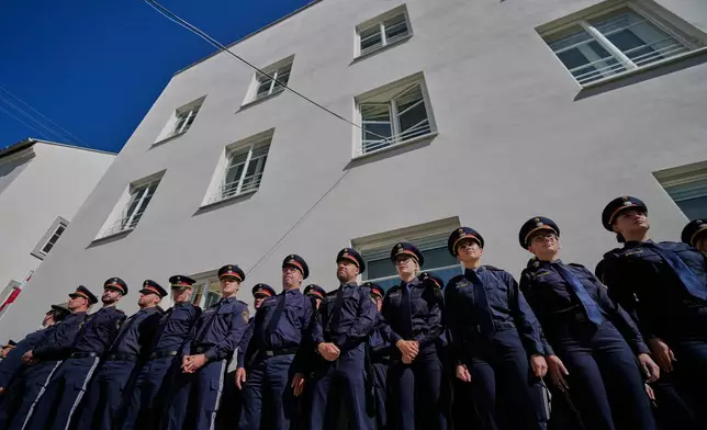 Austrian police officers stand in front of a new police station which is located in Adolf Hitler's birth house in Braunau am Inn, Austria, Wednesday, July 22, 2026. (AP Photo/Matthias Schrader)