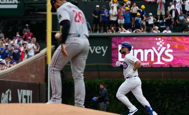 Chicago Cubs' Michael Busch, right, rounds the bases after hitting a solo home run as Minnesota Twins starting pitcher Taj Bradley looks down during the first inning of a baseball game in Chicago, Saturday, July 18, 2026. (AP Photo/Nam Y. Huh)