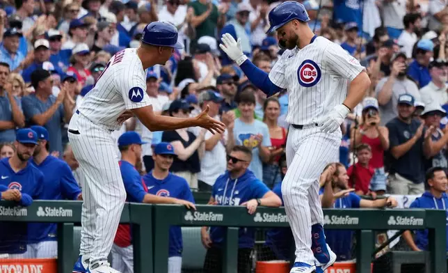 Chicago Cubs' Michael Busch, right, celebrates with third base coach Quintin Berry after hitting a solo home run during the first inning of a baseball game against the Minnesota Twins in Chicago, Saturday, July 18, 2026. (AP Photo/Nam Y. Huh)