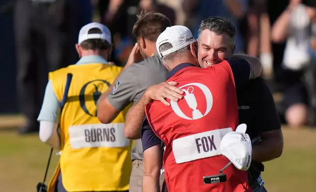Ryan Fox of New Zealand hugs his caddie Dean Smith after winning the British Open Golf championships at Royal Birkdale golf club, in Southport, England, Sunday, July 19, 2026. (AP Photo/David Goldman)