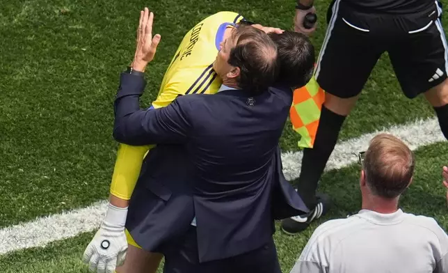 Belgium head coach Rudi Garcia hugs goalkeeper Thibaut Courtois (1) after he was substitued due to an injury during the World Cup quarterfinal soccer match between Spain and Belgium in Inglewood, Calif., near Los Angeles, Friday, July 10, 2026. (AP Photo/Marcio J. Sanchez)