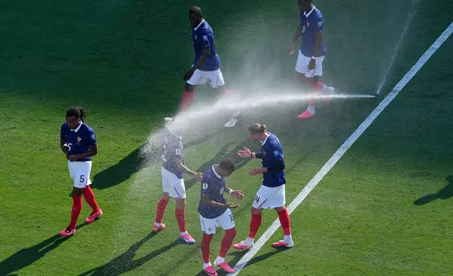 French players cool off from field sprinklers during the World Cup round of 32 soccer match against Sweden in East Rutherford, N.J., near New York, Tuesday, June 30, 2026. (AP Photo/Petr David Josek)