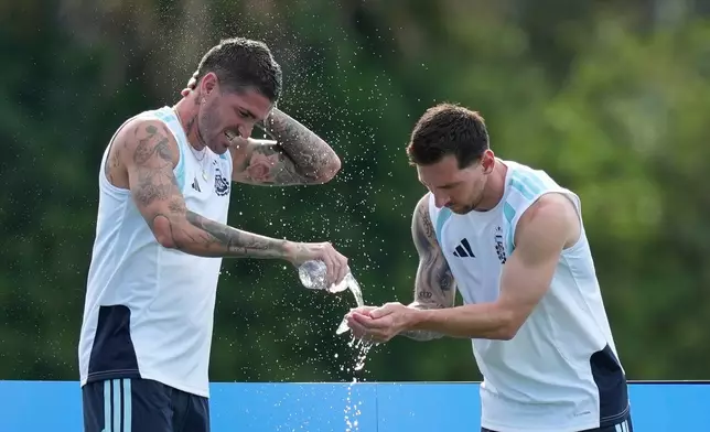Argentina's Lionel Messi, right, and Rodrigo De Paul splash water on themselves to cool down during a training session on the eve of their World Cup round of 32 soccer match against Cape Verde, in Fort Lauderdale, Fla., Thursday, July 2, 2026. (AP Photo/Rebecca Blackwell)