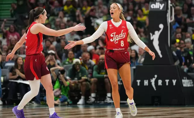 Indiana Fever guard Caitlin Clark, left, greets guard Sophie Cunningham (8) after Cunningham made a basket against the Seattle Storm during the first half of a WNBA basketball game, Tuesday, July 28, 2026, in Seattle. (AP Photo/Lindsey Wasson)