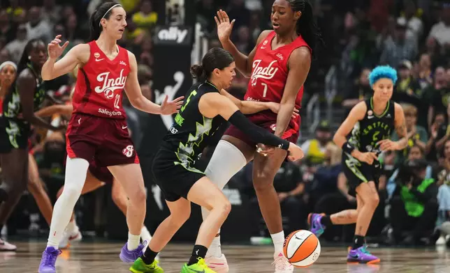 Seattle Storm guard Jade Melbourne, center, loses the ball against Indiana Fever guard Caitlin Clark, left, and center/forward Aliyah Boston, right, during the first half of a WNBA basketball game, Tuesday, July 28, 2026, in Seattle. (AP Photo/Lindsey Wasson)