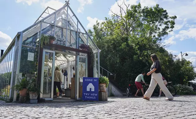A woman enters fine-dining restaurant Noma's cafe and shop in Copenhagen, Denmark Tuesday, July 28, 2026. (AP Photo/James Brooks)