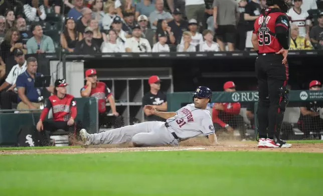 Houston Astros' LaMonte Wade Jr, left, is safe at as Chicago White Sox catcher Drew Romo, right, stands nearby during the sixth inning of a baseball game Friday, July 24, 2026, in Chicago. (AP Photo/David Banks)