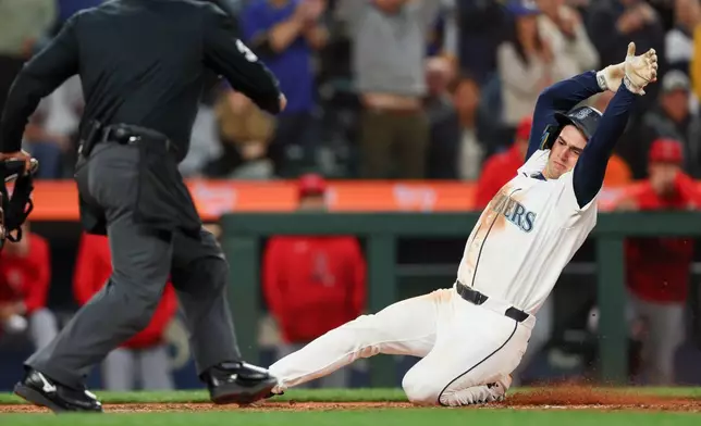 Seattle Mariners' Cole Young slides home on a single hit by Victor Robles in the seventh inning of a baseball game against the Los Angeles Angels, Tuesday, June 30, 2026, in Seattle. (AP Photo/Kevin Ng)