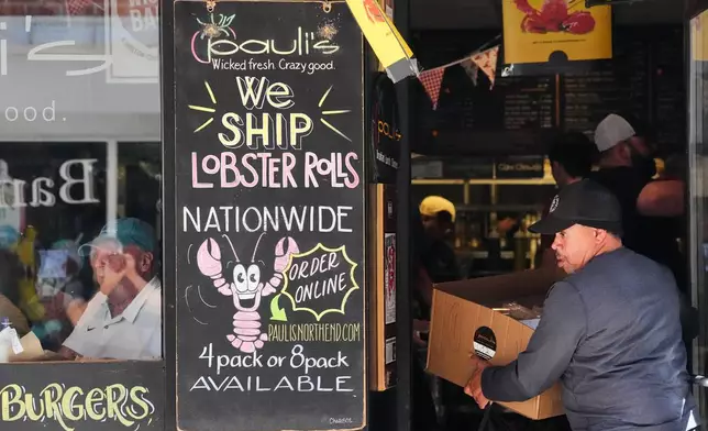 A man picks up a sandwich delivery at Pauli's sandwich shop in the North End of Boston, Wednesday, June 24, 2026. (AP Photo/Martin Meissner)