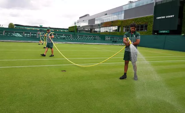 Ground staff waters a court one day ahead of the start of the Wimbledon Tennis Championships in London, Sunday, June 28, 2026.(AP Photo/Kirsty Wigglesworth)