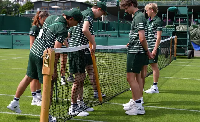 Ground staff fixes the net of a court one day ahead of the start of the Wimbledon Tennis Championships in London, Sunday, June 28, 2026.(AP Photo/Maja Smiejkowska)