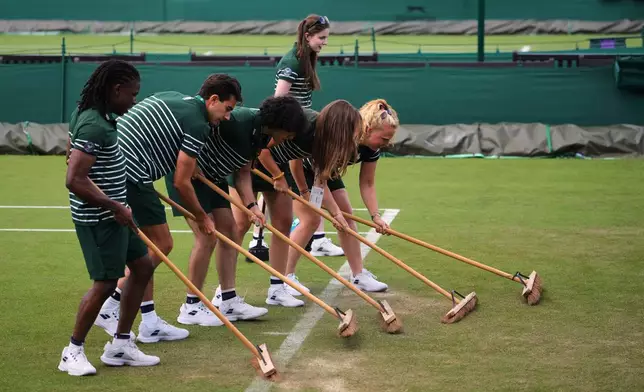 Ground staff works on the court on day two of the Wimbledon Tennis Championships in London, Tuesday, June 30, 2026.(AP Photo/Kin Cheung)