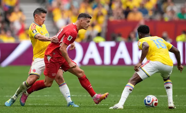 Switzerland's Granit Xhaka, center, tries to get past Colombia's James Rodríguez, left, and Jefferson Lerma during the World Cup round of 16 soccer match between Switzerland and Colombia in Vancouver, British Columbia, Tuesday, July 7, 2026. (AP Photo/Lindsey Wasson)