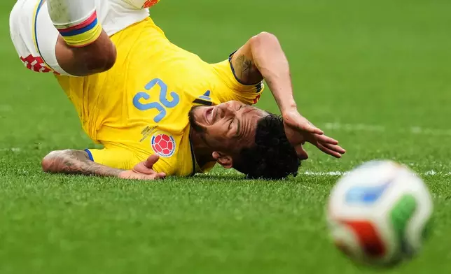 Colombia's Luis Suarez (25) tumbles while fighting for the ball with Switzerland's Breel Embolo during the World Cup round of 16 soccer match between Switzerland and Colombia in Vancouver, British Columbia, Tuesday, July 7, 2026. (Ethan Cairns/The Canadian Press via AP)