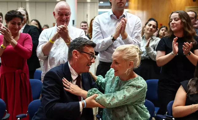 Andy Burnham hugs his wife Marie-France van Heel as he is confirmed as the Labour Party's new leader and the country's next prime minister, during 'Labour's Special Conference' in central London, Friday July 17, 2026. (Henry Nicholls/Pool Photo via AP)