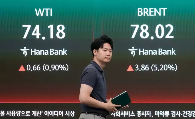 A currency trader passes by a screen showing international oil prices at the foreign exchange dealing room of the Hana Bank headquarters in Seoul, South Korea, Thursday, July 9, 2026. (AP Photo/Ahn Young-joon)