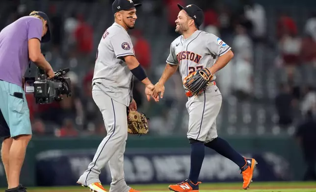 Houston Astros' Jose Altuve (27) and Isaac Paredes (15) celebrate their win over the Los Angeles Angels during a baseball game Monday, July 27, 2026, in Anaheim, Calif. (AP Photo/Scott Strazzante)