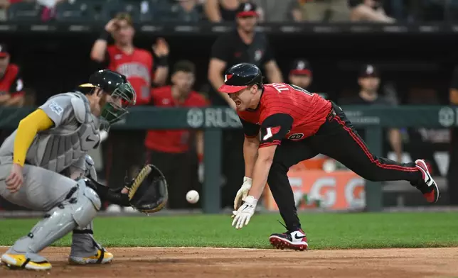 Chicago White Sox's Kyle Teel, right, dives at home plate as The Athletics catcher Jonah Heim, left, prepares to catch the throw during the fifth inning of a baseball game in Chicago, Friday, July 10, 2026. (AP Photo/Paul Beaty)
