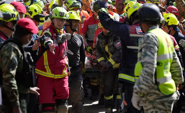 Rescue workers carry Hernán Alberto Gil Flores Gil after he was pulled from the rubble eight days after he was trapped by twin earthquakes that struck Catia La Mar, Venezuela, Thursday, July 2, 2026. (AP Photo/Fernando Vergara)