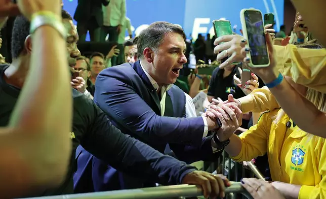 Brazilian Sen. Flavio Bolsonaro greets supporters as he arrives to the Liberal Party convention where he was confirmed as the party's presidential candidate, in Sao Paulo, Saturday, July 25, 2026. (AP Photo/Ettore Chiereguini)