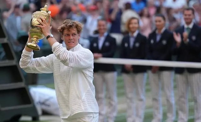 Jannik Sinner of Italy celebrates with his trophy after winning against Alexander Zverev of Germany in the men's singles final at Wimbledon Tennis Championships in London, Sunday, July 12, 2026. (AP Photo/Kirsty Wigglesworth)