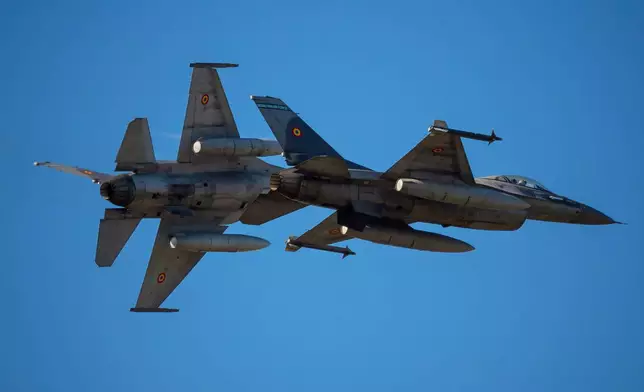 FILE - Pilots of the Romanian Air Force fly F-16 fighter jets above the runway of the Aurel Vlaicu airport, on the first day of the Bucharest International Air Show, BIAS, in Bucharest, Romania, Saturday, Aug. 30, 2025. (AP Photo/Andreea Alexandru, File)