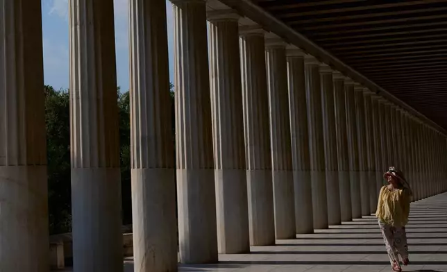 A tourist walks through the Stoa of Attalos at the Ancient Agora during a heat wave in Athens, Greece, Monday, July 20, 2026. (AP Photo/Petros Giannakouris)