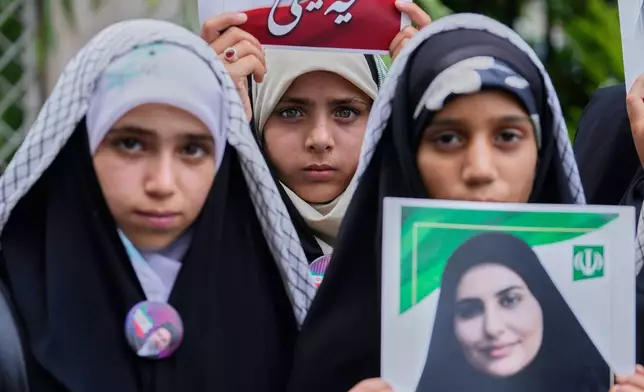 Shiite Muslims hold portraits of schoolchildren killed in a strike on a school in the southern Iranian town of Minab on Feb. 28 as they express solidarity with Iran in Magam, north of Srinagar in Indian controlled Kashmir, Sunday, July 19, 2026. (AP Photo/Mukhtar Khan)