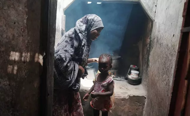 Maryam Aminu stands next to her daughter Farisa, who has relapsed into malnutrition, in front of their kitchen in Kware Sokoto, northwestern Nigeria, Wednesday, July 15, 2026. (AP Photo/Sunday Alamba)