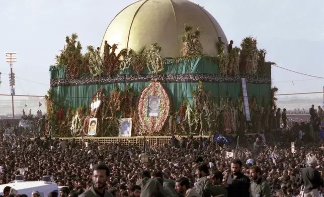FILE- Thousands of mourners crowd around the grave of the late Ayatollah Khomeini at the cemetery in Beheshte e Zahra, some 70 kms from Tehran, Iran, June 11, 1989. (AP Photo/Heribert Proepper, File)