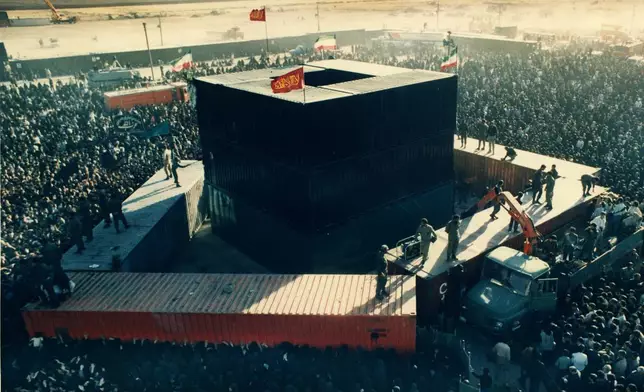 FILE - Mourners crowd around some containers set around the the grave site of the late Ayatollah Khomeini at the cemetery in Beheshte e Zahra, some 70 kms from Tehran, Iran, Sunday June 8, 1989. . (AP Photo/Dusan Vranic, File)