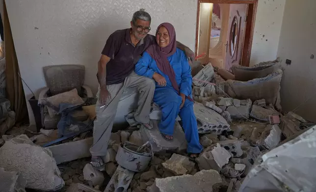Mahasen Faqih and her husband, Mohammed Sobeih, smile as they sit amid the rubble of their home after returning to it following the Israeli military operation in Zawtar al-Gharbieh, Lebanon, Tuesday, July 28, 2026. (AP Photo/Hassan Ammar)
