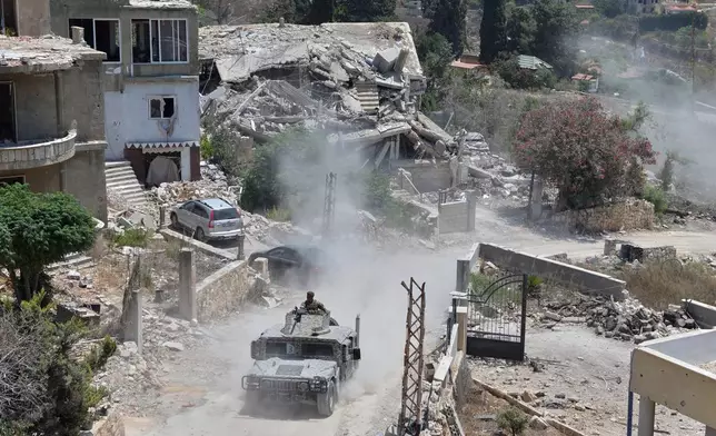 A Lebanese military vehicle drives past homes damaged during the war in the southern village of Zawtar al-Gharbieh, Lebanon, Monday, July 27, 2026. (AP Photo/Mustafa Jamalddine)