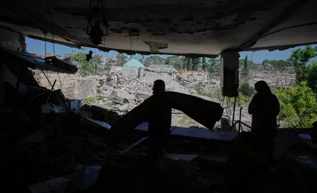 Mahasen Faqih and her husband, Mohammed Sobeih, stand inside their destroyed home overlooking the rubble of their neighborhood after returning to it following the Israeli military operation in Zawtar al-Gharbieh, Lebanon, Tuesday, July 28, 2026. (AP Photo/Hassan Ammar)