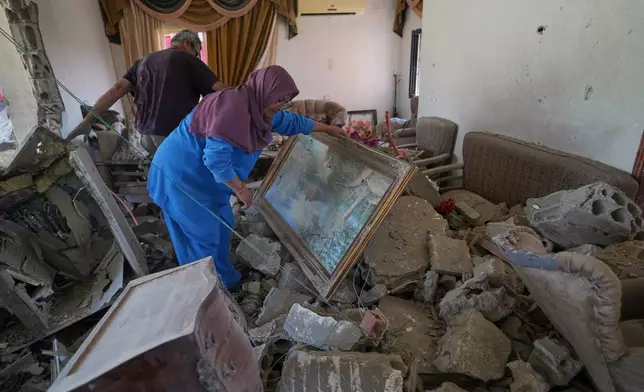 Mahasen Faqih and her husband, Mohammed Sobeih, inspect their home, destroyed during the Israeli military operation, after returning to it in Zawtar al-Gharbieh, Lebanon, Tuesday, July 28, 2026. (AP Photo/Hassan Ammar)