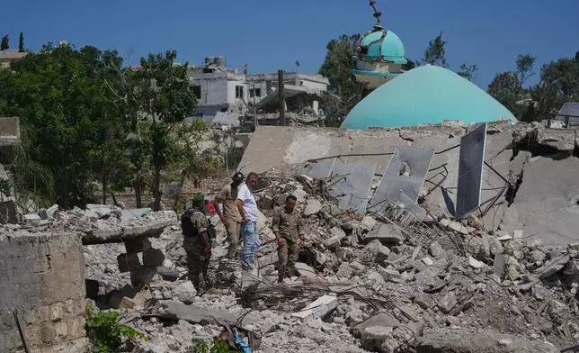 Lebanese soldiers and a resident inspect the rubble of a home destroyed during an Israeli military operation in Zawtar al-Gharbieh, southern Lebanon, Tuesday, July 28, 2026. (AP Photo/Hassan Ammar)