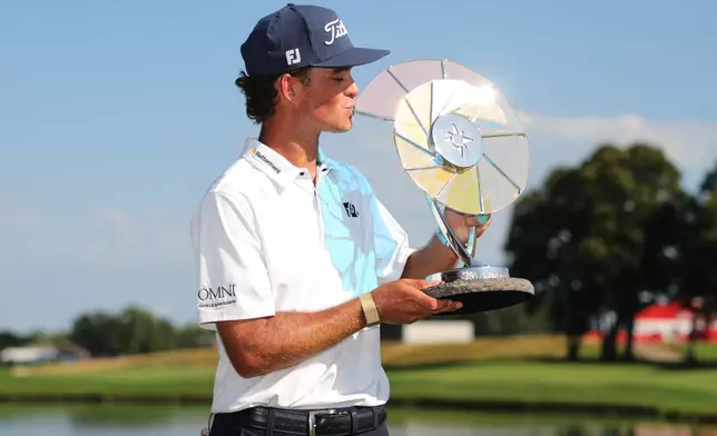 Jackson Koivun kisses his trophy after winning the 3M Open golf tournament at the Tournament Players Club Sunday, July 26, 2026, in Blaine, Minn. (AP Photo/Bailey Hillesheim)