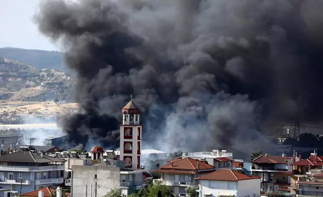 Thick smoke rises above Filothei settlement during a wildfire on the outskirts of the northern city of Thessaloniki, Greece, Sunday, July 5, 2026. (AP Photo/Giannis Papanikos)