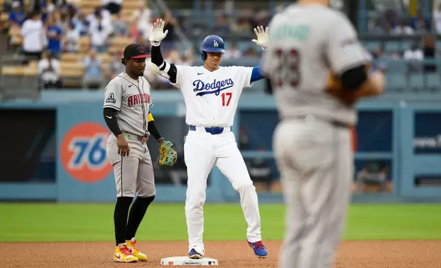 Los Angeles Dodgers' Shohei Ohtani (17) celebrates after hitting a double a double during the third inning of a baseball game against the Arizona Diamondbacks in Los Angeles, Sunday, July 12, 2026. (AP Photo/Kyusung Gong)