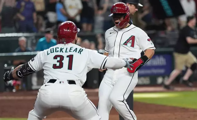 Arizona Diamondbacks' Jorge Barrosa, right, celebrates scores the winning run against the St. Louis Cardinals with Diamondbacks Tyler Locklear (31) during the 10th inning of a baseball game, Sunday, July 19, 2026, in Phoenix. (AP Photo/Ross D. Franklin)