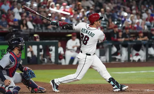 Arizona Diamondbacks' Nolan Arenado (28) watches the flight of his two-run home run as St. Louis Cardinals catcher Iván Herrera looks on during the eighth inning of a baseball game, Sunday, July 19, 2026, in Phoenix. (AP Photo/Ross D. Franklin)