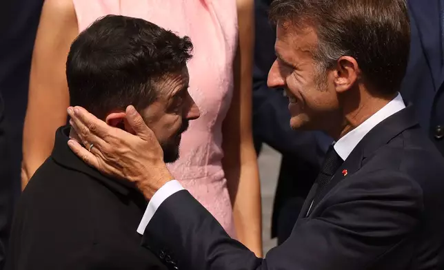 French President Emmanuel Macron, right, speaks with Ukraine's President Volodymyr Zelensky after the Bastille Day military parade on the Champs-Elysees avenue, in Paris, Tuesday, July 14, 2026. (AP Photo/Thomas Padilla)