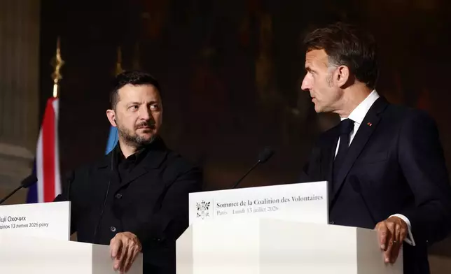 Ukrainian President Volodymyr Zelensky, left, and French President Emmanuel Macron address a press conference after the Coalition of the Willing summit on security guarantees for Ukraine in Paris, Monday, July 13, 2026. (Teresa Suarez/Pool Photo via AP)