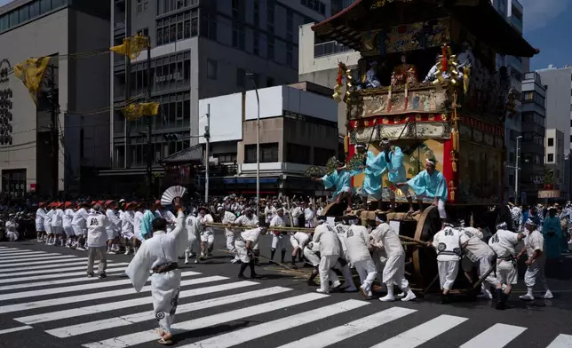 People carry the "Niwatori Hoko" float during one of the main parades of Shinto's Gion Matsuri festival in Kyoto, western Japan, Friday, July 17, 2026. (AP Photo/Fred Mery)
