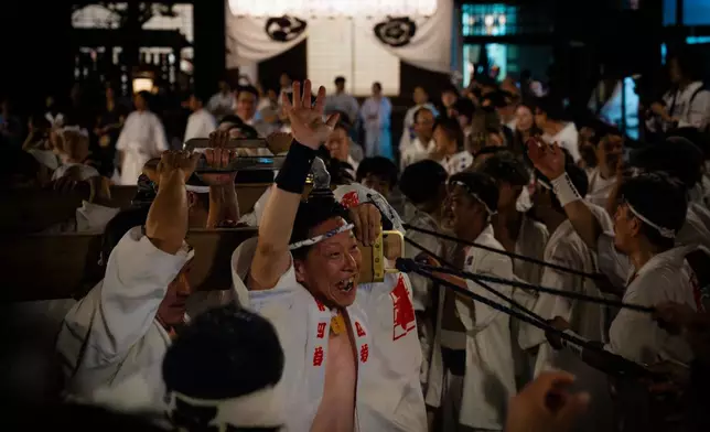 Festival participants carry Yasaka Shrine's Eastern Mikoshi back into the shrine's main hall following the "Mikoshi Arai" purification ritual ahead of the Gion Matsuri festival in Kyoto, western Japan, Friday, July 10, 2026. (AP Photo/Fred Mery)