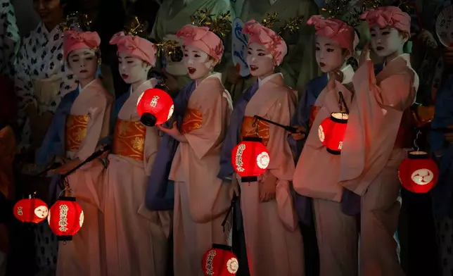 Young women dressed in traditional attire take part in the "Mikoshi Arai" purification ritual ahead of the Gion Matsuri festival in Kyoto, western Japan, Friday, July 10, 2026. (AP Photo/Fred Mery)