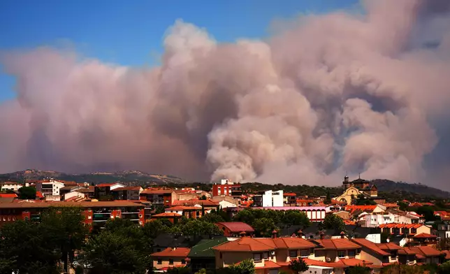 Smoke and flames rise as a wildfire advances near La Adrada, Ávila province, Spain, Friday, July 24, 2026. (AP Photo/Manu Fernandez)